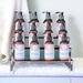 Twelve bottles of luxurious lotions by Whole Self Aromatherapy on a display sitting atop a soft white towel with spa towels hung alongside.