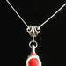 Beautiful Coral stone is viewed on a flute trill key.  A fleur de lis bail on a  16" silver plated snake chain.