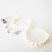Hand knotted creamy white pearl choker necklace with extender chain, accented with a blue crystal.