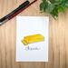 Watercolor and ink print of a sliced block of cheddar cheese on a white background. The word Cheese is handwritten below the cheese.