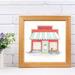A watercolor and ink print of an old red wooden diner with a blue and white awning. Surfboards, a fishing pole, and a bike sit outside.