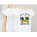 white baby bodysuit with newest member of the camping crew on front pictured with camping scene  tent surrounded by trees and firepit