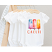 white baby bodysuit with three popscicles on front in hues of red purple blue yellow orange. Baby name written across bottom in orange print