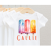 White baby bodysuit with three watercolor popscicles blue purple red yellow hues. baby name across bottom in orange print font.
