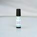 Best Man aromatherapy roller bottle on a matte white surface against a white wall with a subtle shadow where they meet.