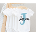 Large blue first initial with baby name in black script over top on white baby bodysuit available in long sleeves or short