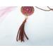 A leather tassel hanging from the bottom of a resin, stained glass pendant