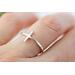 Thin sterling silver ring with a sideways cross.
