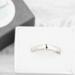 Sterling silver semicolon awareness ring with subtle symbol, on white surface supporting mental health and suicide prevention.
