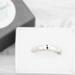 Sterling silver semicolon awareness ring with subtle symbol, on white surface, supporting mental health and suicide prevention.
