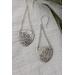 Sterling silver trillion shape imprinted with a mandala design hanging from sterling silver chain from two corners and a sterling ear wire. 