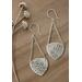 Sterling silver trillion shape imprinted with a mandala design hanging from sterling silver chain from two corners and a sterling ear wire. 
