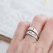 Hand with two sterling silver rings, "YOU SAY" and cross design.
