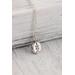 small silver charm made from a recycled silver ball hammered flat and stamped with a fern design on a sterling silver chain.