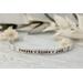 Sterling silver cuff bracelet stamped with kids names in a delicate handwritten font with a stamped for detail on both sides.