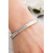 A close-up of a sterling silver floral cuff bracelet worn on a wrist, showcasing its elegant design and fit.