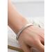 A close-up of a sterling silver floral cuff bracelet worn on a wrist, showcasing its elegant design and fit.