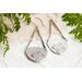 Trillion shaped sterling silver earrings stamped with a floral design hanging from sterling silver chain a French hook ear wire. 