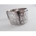 Wide sterling silver bracelet with floral textured overlay.