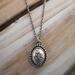 Handcrafted sterling silver lotus flower yoga necklace on wooden background, 16"-20" chain, unique gift design.
