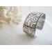 Wide sterling silver cuff bracelet with layered scrollwork pattern. 