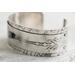 Sterling silver cuff bracelet with embossed arrow overlay accented with a genuine turquoise cabochon. 