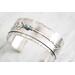 Sterling silver cuff bracelet with embossed arrow overlay accented with a genuine turquoise cabochon. 