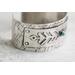 Sterling silver cuff bracelet with embossed arrow overlay accented with a genuine turquoise cabochon. 