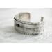 Sterling silver cuff bracelet with embossed arrow overlay accented with a genuine turquoise cabochon. 