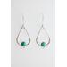 Two sterling silver teardrop-shaped earrings, each featuring a turquoise gemstone set in a detailed bezel on a white backdrop. 