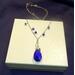 Image is of a Blue Crystal Teardrop Pendant wire wrapped on a chain. Blue Swarovski Crystals are wire wrapped onto the chain.  19" long