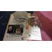 Photo is of packaging including jewelry, tissue paper, business card and a coupon card. 