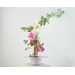 photo of kiln-fired copper enamel ikebana-style vase with hand painted hibiscus on top with is 4 inches in diameter. Enamel colors of hibiscus are pale pink and lavender, with pale green leaves. Vase stands 1-1/4 inch tall. There is a pin-frog inside to hold flowers upright.