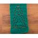Close-up of a green scarf showing details of a tree in the pattern.