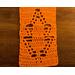 Close-up of an orange scarf showing details of a leaf in the pattern.