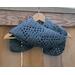 A grey vine crochet scarf display.