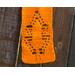 Close-up of an orange scarf showing details of a leaf in the pattern.