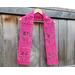 Display of the Tulip Crochet Scarf Pattern on a hanger in front of a wooden fence.
