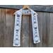 Snowman scarf on a hanger in front of a wooden fence.