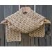A tan shell crochet scarf display.