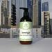 Energy Hand & Body Lotion on white window sill with a cityscape in the background, aromatherapy skincare, Whole Self Aromatherapy.