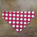 Over the collar dog bandana that is reversible from anchors to red with white polka dots, polka dot side