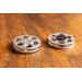 top view of a silver miniature movie reel magnet sitting on a wooden table