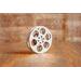 front view of a silver miniature movie reel magnet sitting on a wooden table