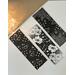black and white floral bookmark set of 3 on a white table with a light brown table runner with fairy lights in a jar in the left-hand corner