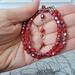 Red faceted glass choker necklace in hand.