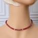 Deep red faceted glass beaded choker necklace on mannequin.