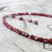 Red faceted glass beads, half coated in silver tone.