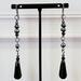 Long black teardrop dangle earrings with cultured pearls.