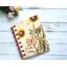 A small blank kraft paper notebook or journal that has a sunflower and butterfly cover